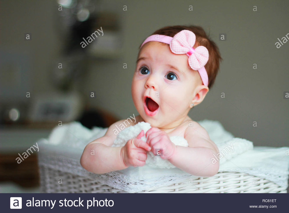 cute-baby-girl-with-a-bow-on-her-hair-with-amazement-face-RC61ET.jpg
